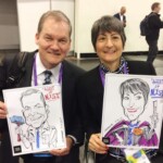Two people sitting side by side, each holding a caricature drawing of themselves labeled "Agent of NIST.