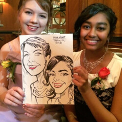 Two young women in formal dresses smile while holding a caricature drawing of themselves labeled "Prom Night March 10, 2018.