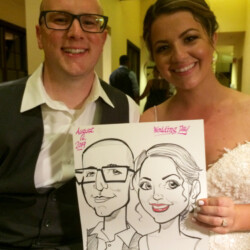A bride and groom smile while holding a caricature drawing of themselves at their wedding.