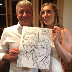 A smiling couple holds a caricature drawing of themselves labeled "Wedding Day" with a date and location.