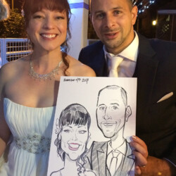 A smiling couple in formal attire holds a caricature drawing of themselves dated November 4th, 2017.