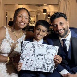 Three people in formal attire smile and hold a caricature drawing of themselves and a dog at an event.